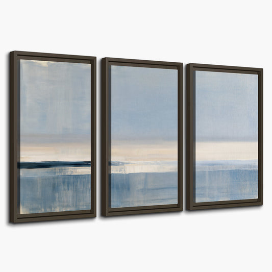 A minimal blue seascape with a pale horizon and soft vertical reflections 3 piece framed canvas wall art on a white background
