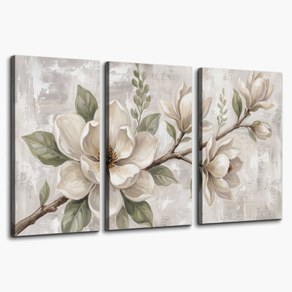 Large ivory magnolia blossoms and soft green leaves on pale gray 3 piece canvas wall art on a white background