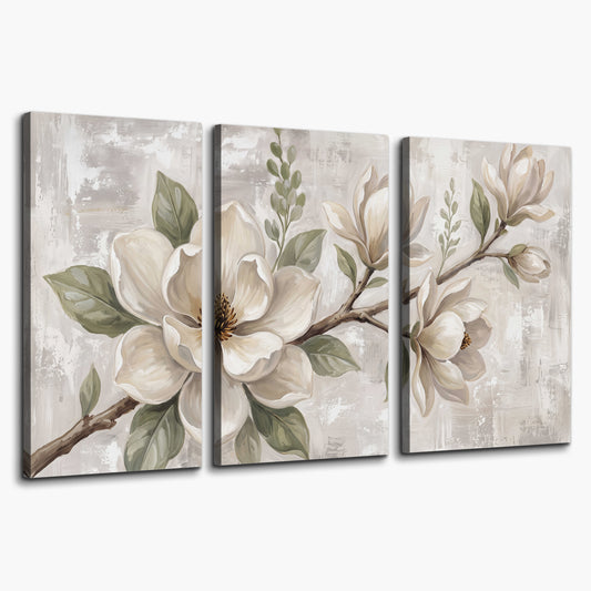 Large ivory magnolia blossoms and soft green leaves on pale gray 3 piece canvas wall art on a white background
