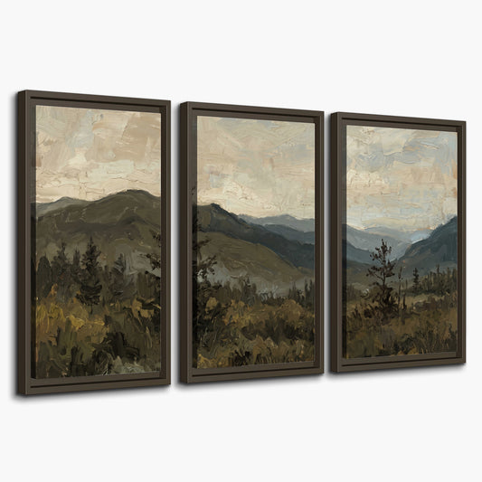 Layered mountain ridges and dark evergreen trees beneath a muted cloudy sky 3 piece framed canvas wall art on a white background