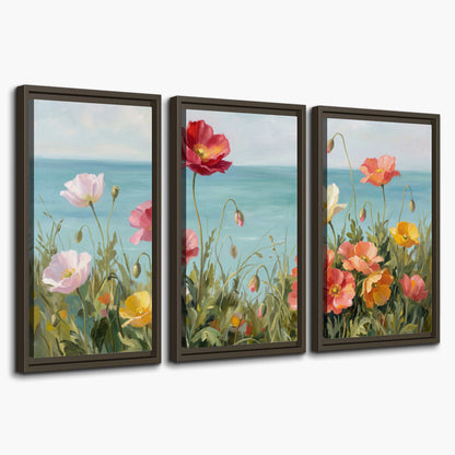 Colorful red, peach and yellow flowers beside a turquoise sea 3 piece framed canvas wall art on a white background