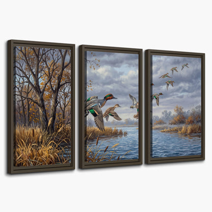 Ducks taking flight over a blue river framed by autumn branches 3 piece framed canvas wall art on a white background