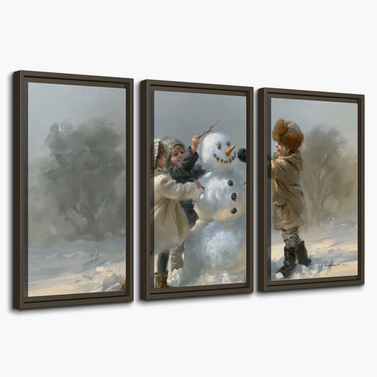 Two children putting the finishing touches on a snowman in a soft snowy landscape 3 piece framed canvas wall art on a white background
