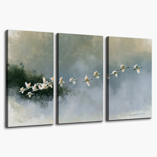A flock of white birds flying low above a quiet blue-green lake 3 piece canvas wall art on a white background