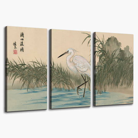A white heron standing beside a quiet river with reeds and distant hills 3 piece canvas wall art on a white background