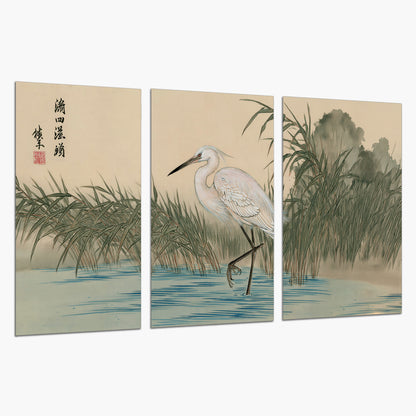 A white heron standing beside a quiet river with reeds and distant hills set of 3 poster prints on a white background