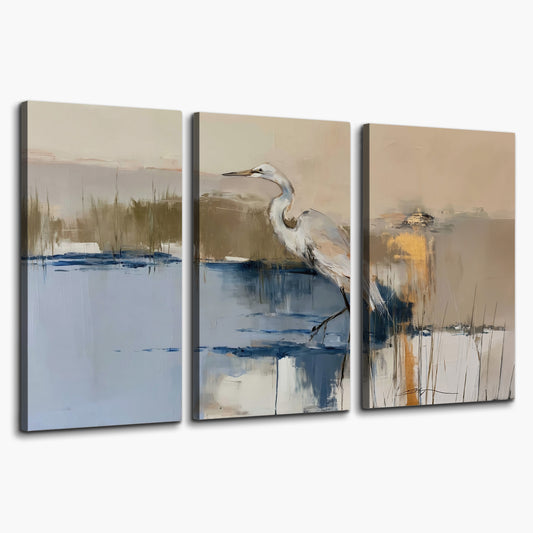A slender heron standing in blue water among loose ochre and cream brushstrokes 3 piece canvas wall art on a white background