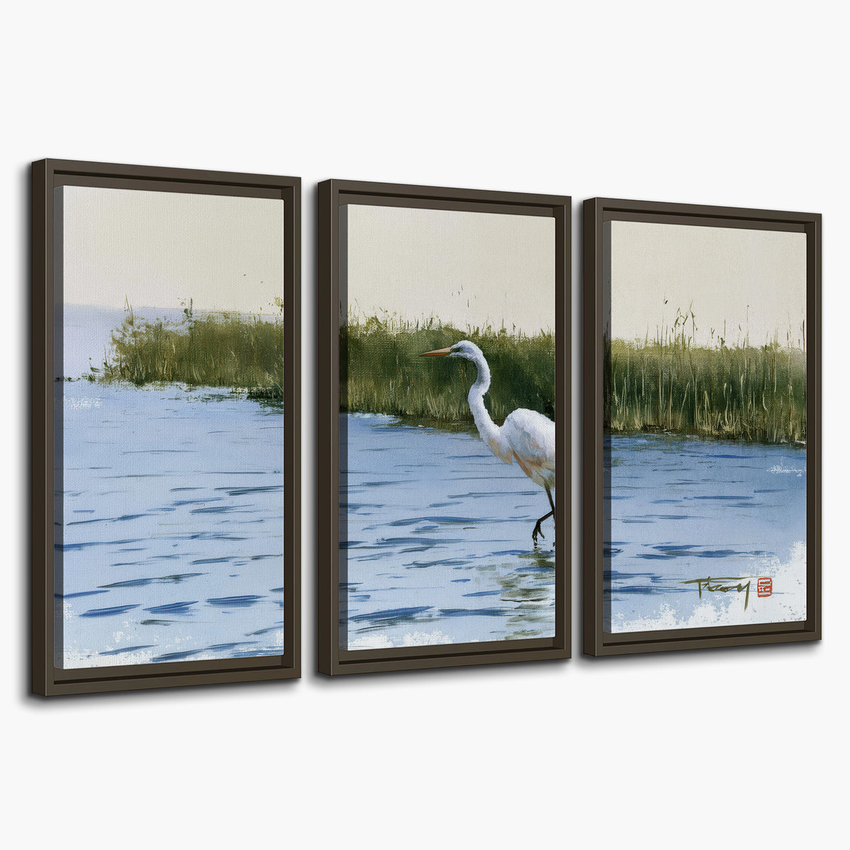 A white heron wading through bright blue water beside green reeds 3 piece framed canvas wall art on a white background