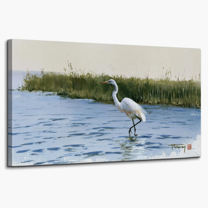 A white heron wading through bright blue water beside green reeds single canvas wall art on a white background