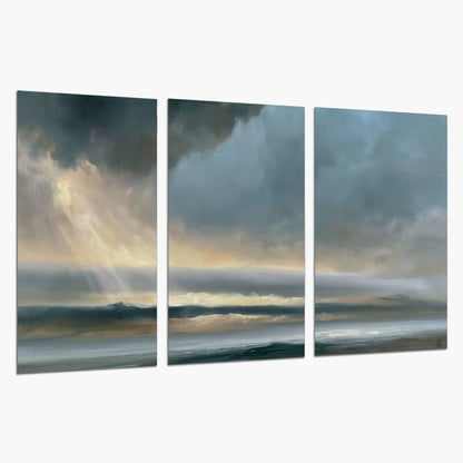 Dramatic blue-gray storm clouds breaking over a pale strip of ocean light set of 3 poster prints on a white background