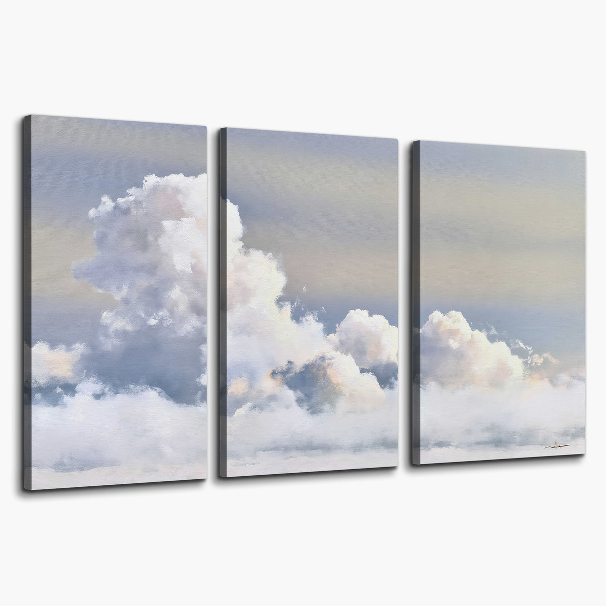 Large white clouds rising through a pale blue sky with gentle warm highlights 3 piece canvas wall art on a white background