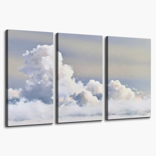 Large white clouds rising through a pale blue sky with gentle warm highlights 3 piece canvas wall art on a white background
