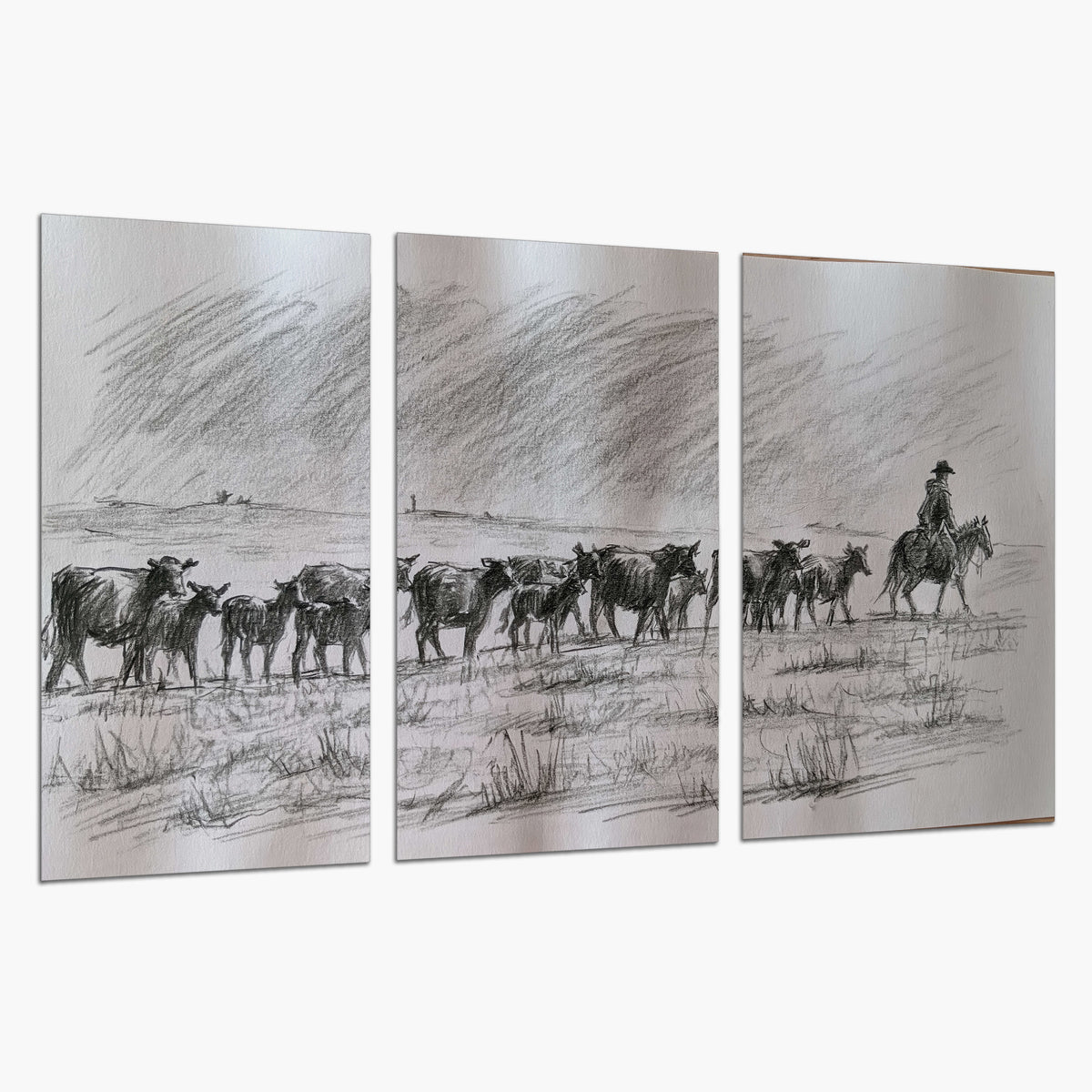 A rider on horseback guiding a herd of cattle across an open plain in charcoal-style strokes set of 3 poster prints on a white background