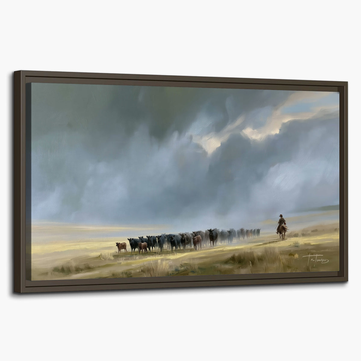 A rider and cattle moving across a sunlit grassland beneath a dramatic blue-gray sky single framed canvas wall art on a white background