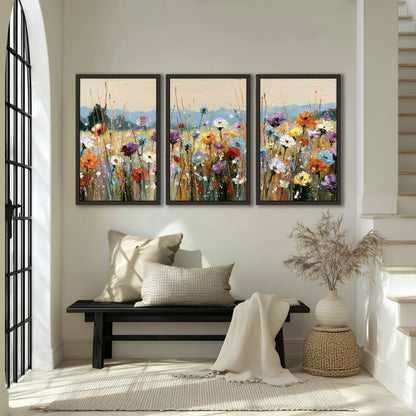 Colorful wildflower meadow painting 3 piece framed canvas in an entryway above a bench