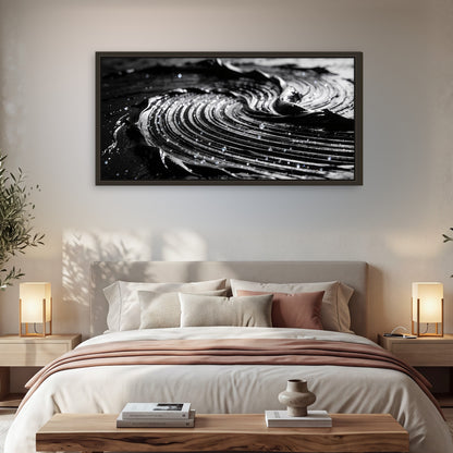 Black and silver swirl abstract painting framed canvas wall art in a bedroom above the bed