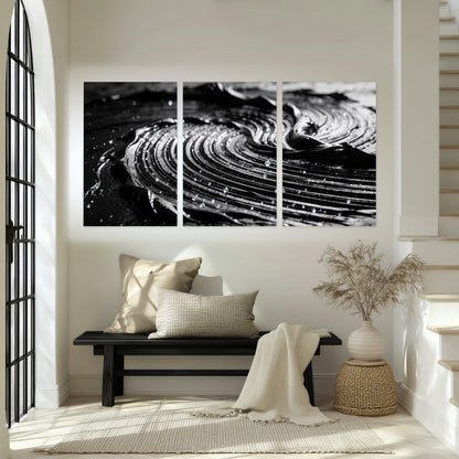 Black and silver swirl abstract painting set of 3 poster prints in an entryway above a bench