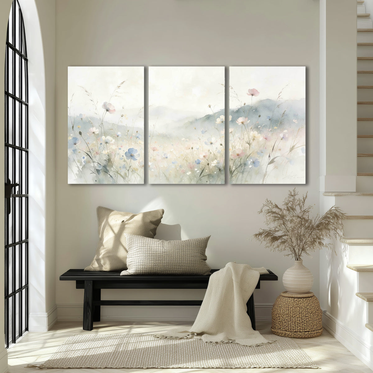 Watercolor wildflower meadow painting 3 piece canvas wall art in an entryway above a bench