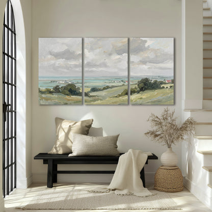 Coastal Countryside 3 piece canvas wall art set hanging in an entryway above a bench