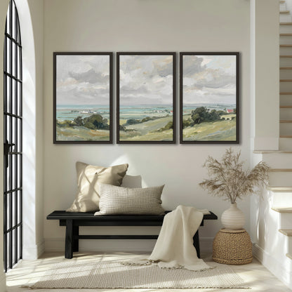 Coastal Countryside 3 piece framed canvas wall art hanging in an entryway with a bench