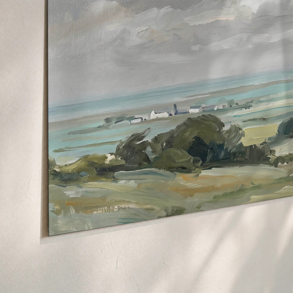 Close-up of matte paper poster print – coastal countryside landscape with green hills and sea