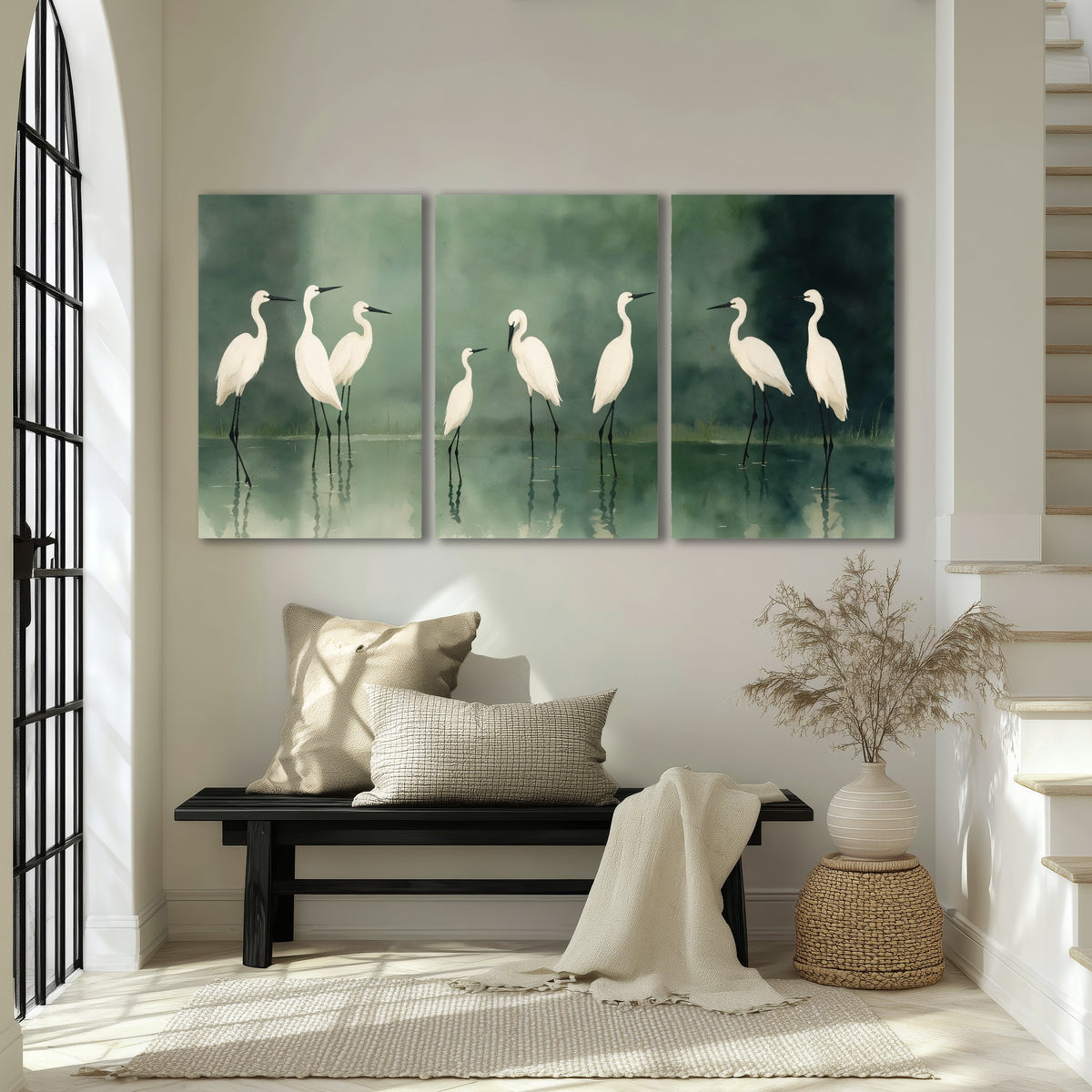 White egrets on green lake painting 3 piece canvas wall art in an entryway above a bench