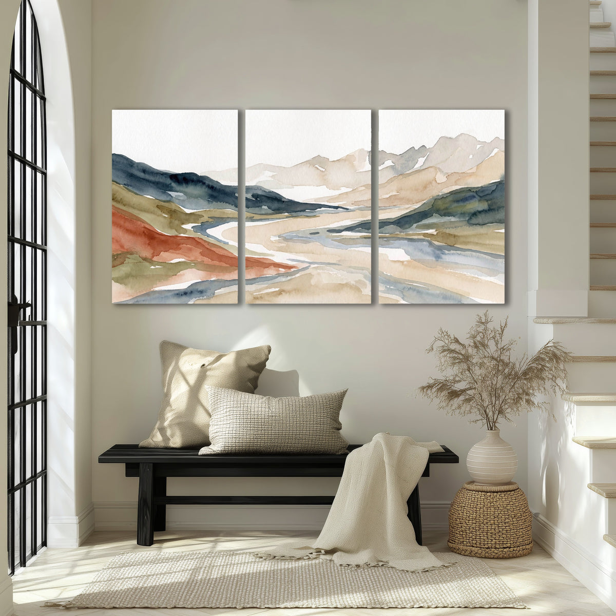 Watercolor mountain valley painting 3 piece canvas wall art in an entryway above a bench