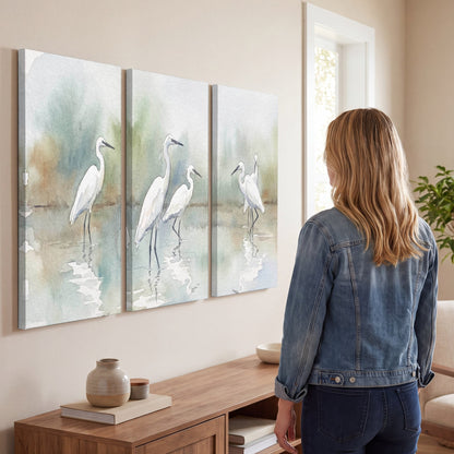 White egrets watercolor 3 piece canvas wall art in a living room