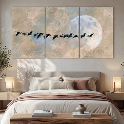Geese flying across the moon painting 3 piece canvas wall art in a bedroom above the bed
