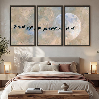 Geese flying across the moon painting 3 piece framed canvas in a bedroom above the bed