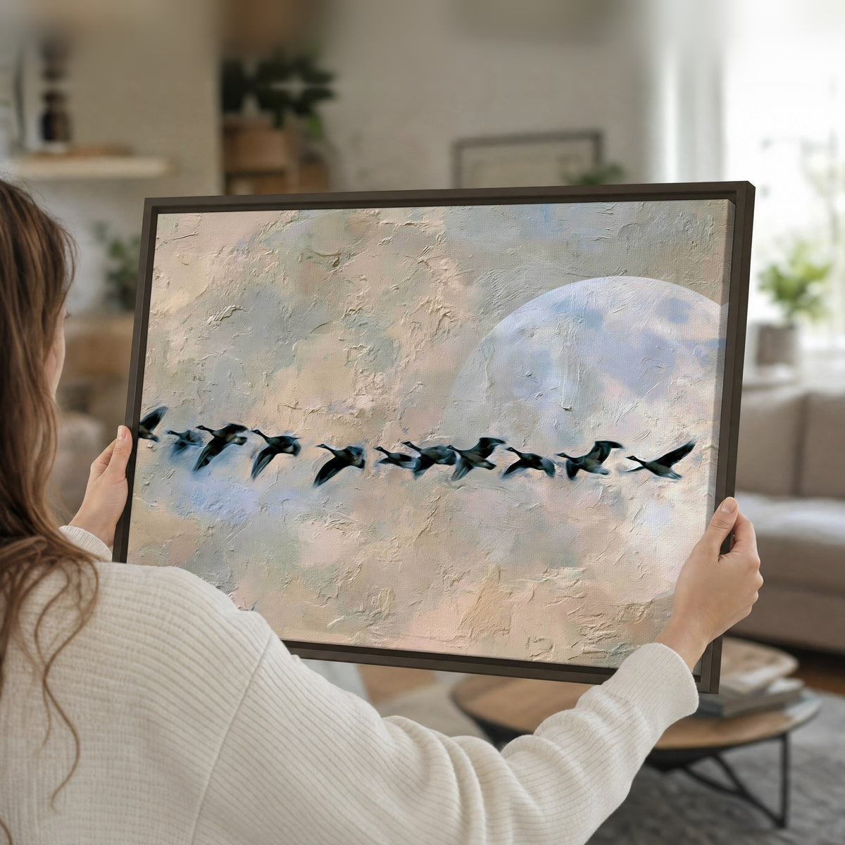 Geese flying across the moon painting framed canvas held in hands