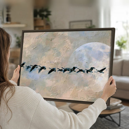 Geese flying across the moon painting framed canvas held in hands