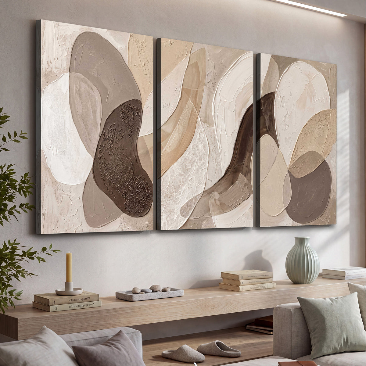Layered organic shapes in taupe, cream and brown 3 piece canvas wall art displayed in a console