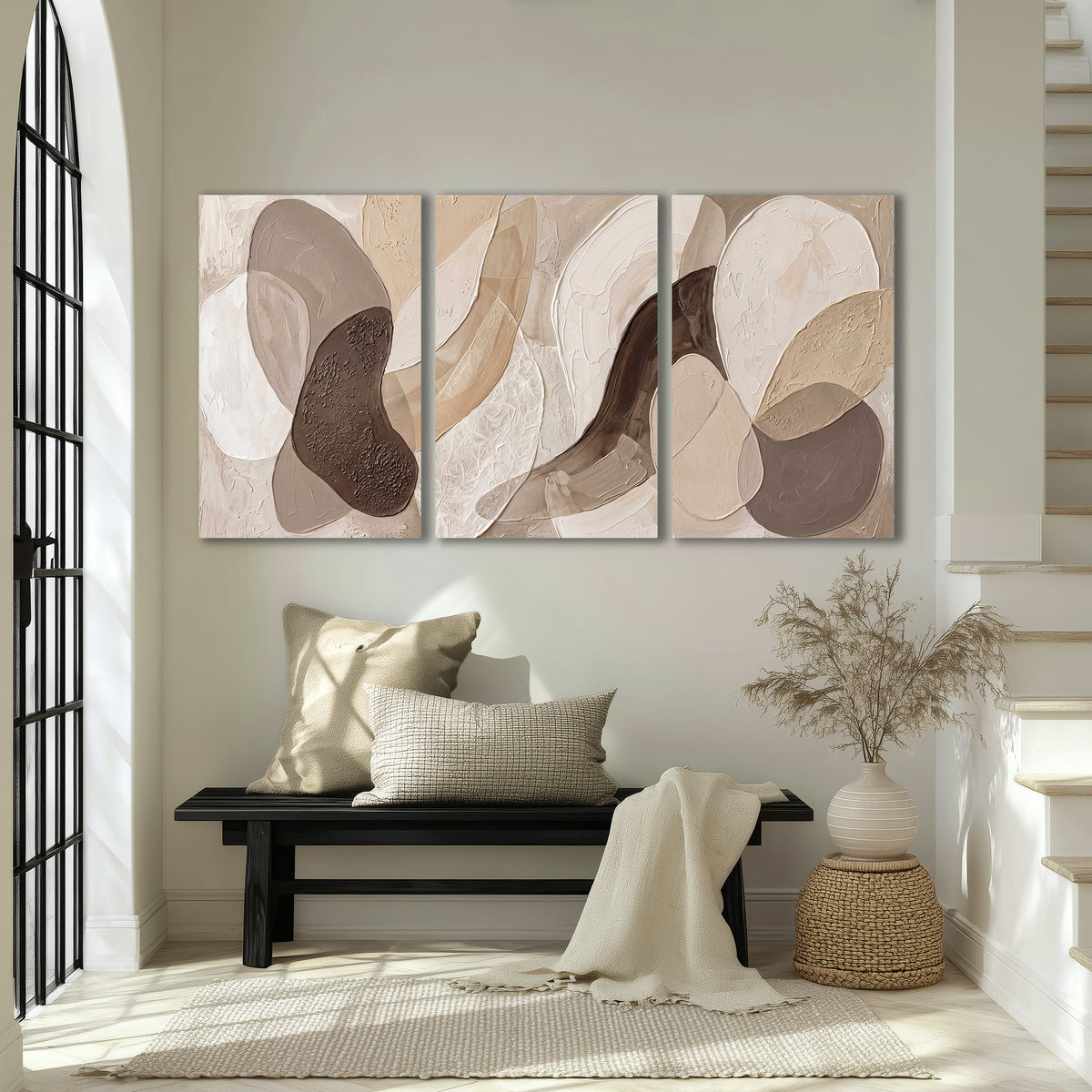 Layered organic shapes in taupe, cream and brown 3 piece canvas wall art displayed in a entryway