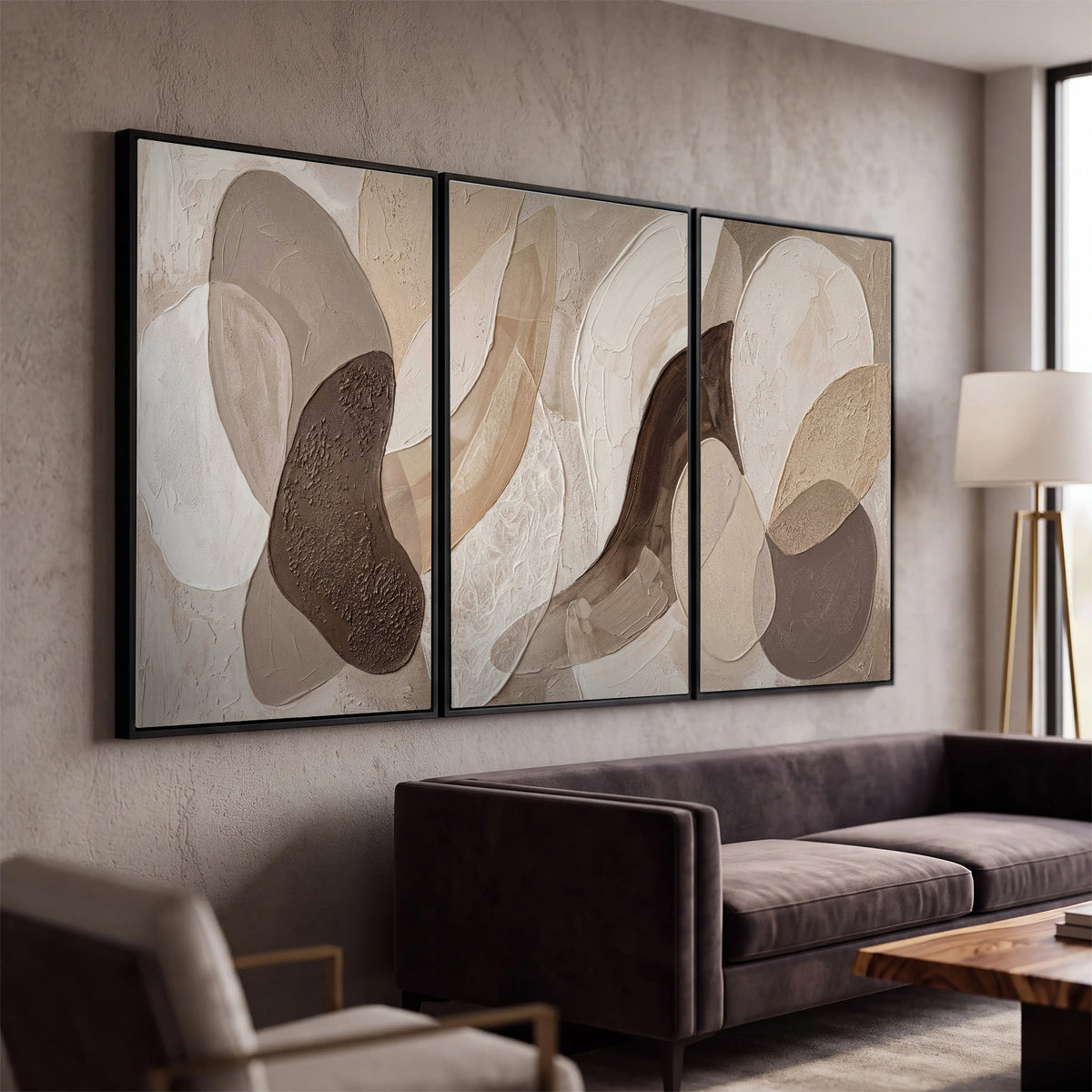 Layered organic shapes in taupe, cream and brown 3 piece framed canvas wall art displayed in a modern living room