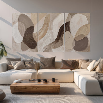 Layered organic shapes in taupe, cream and brown set of 3 poster prints displayed in a living room