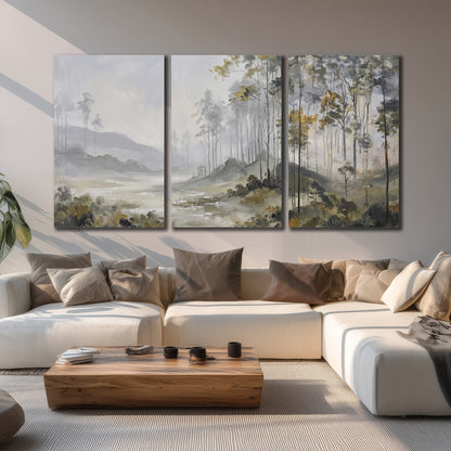 Misty woodland stream with gray trees, muted olive foliage and distant hazy hills 3 piece canvas wall art displayed in a living room