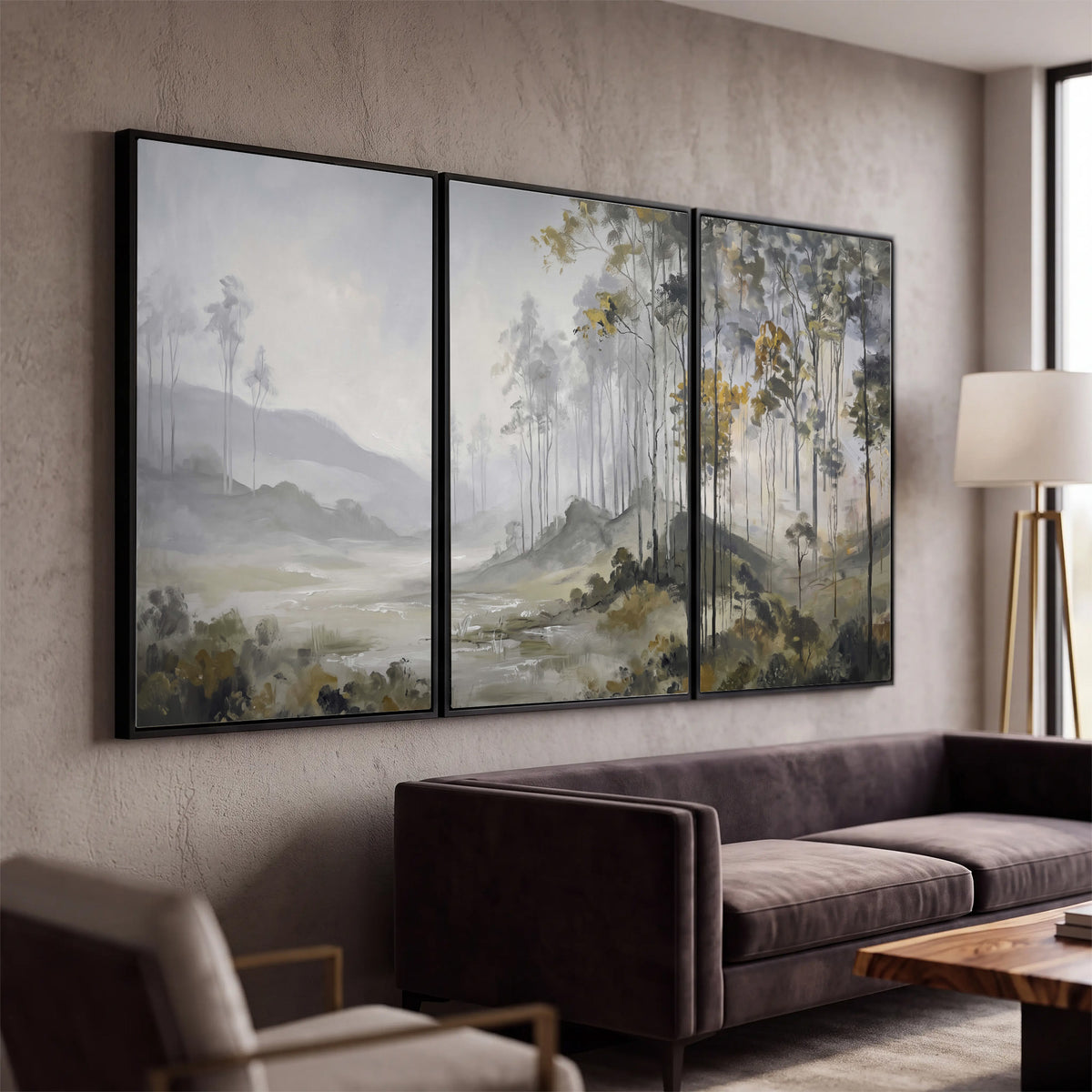 Misty woodland stream with gray trees, muted olive foliage and distant hazy hills 3 piece framed canvas wall art displayed in a modern living room