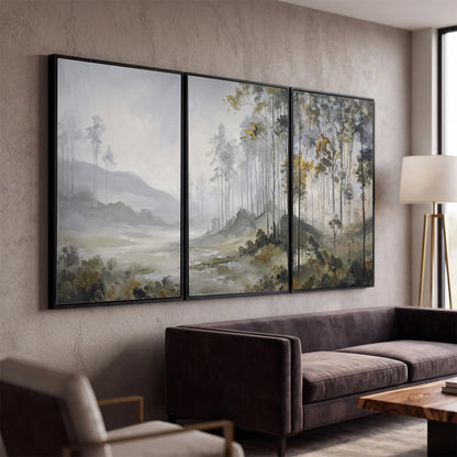 Misty woodland stream with gray trees, muted olive foliage and distant hazy hills 3 piece framed canvas wall art displayed in a modern living room