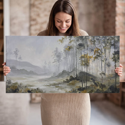 Misty woodland stream with gray trees, muted olive foliage and distant hazy hills single canvas wall art held in hands