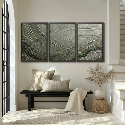 Olive and sage green abstract flowing waves with curved painted-style ridges 3 piece framed canvas wall art displayed in a entryway
