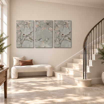 Small songbirds among pink and cream blossoms, green leaves and delicate branches on gray 3 piece canvas wall art styled in an interior