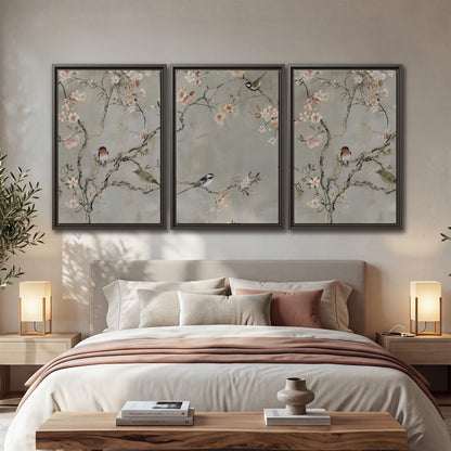 Small songbirds among pink and cream blossoms, green leaves and delicate branches on gray 3 piece framed canvas wall art displayed in a bedroom