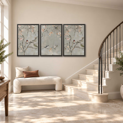 Small songbirds among pink and cream blossoms, green leaves and delicate branches on gray 3 piece framed canvas wall art styled in an interior