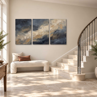 Sweeping charcoal and cream painted clouds with warm gold tones 3 piece canvas wall art styled in an interior