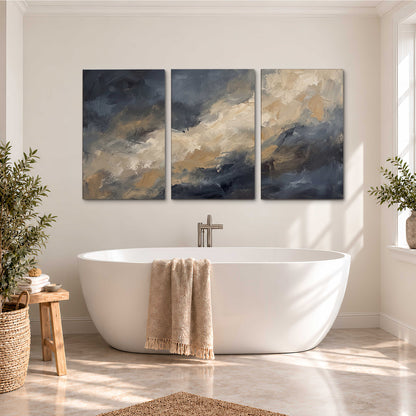 Sweeping charcoal and cream painted clouds with warm gold tones 3 piece canvas wall art styled in an interior