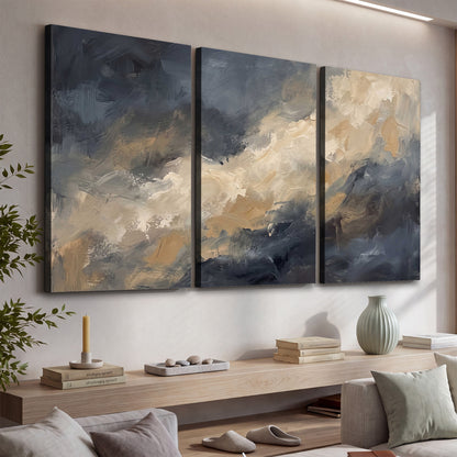 Sweeping charcoal and cream painted clouds with warm gold tones 3 piece canvas wall art displayed in a console