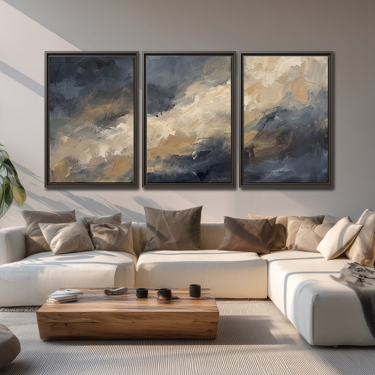 Sweeping charcoal and cream painted clouds with warm gold tones 3 piece framed canvas wall art displayed in a living room