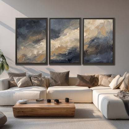 Sweeping charcoal and cream painted clouds with warm gold tones 3 piece framed canvas wall art displayed in a living room