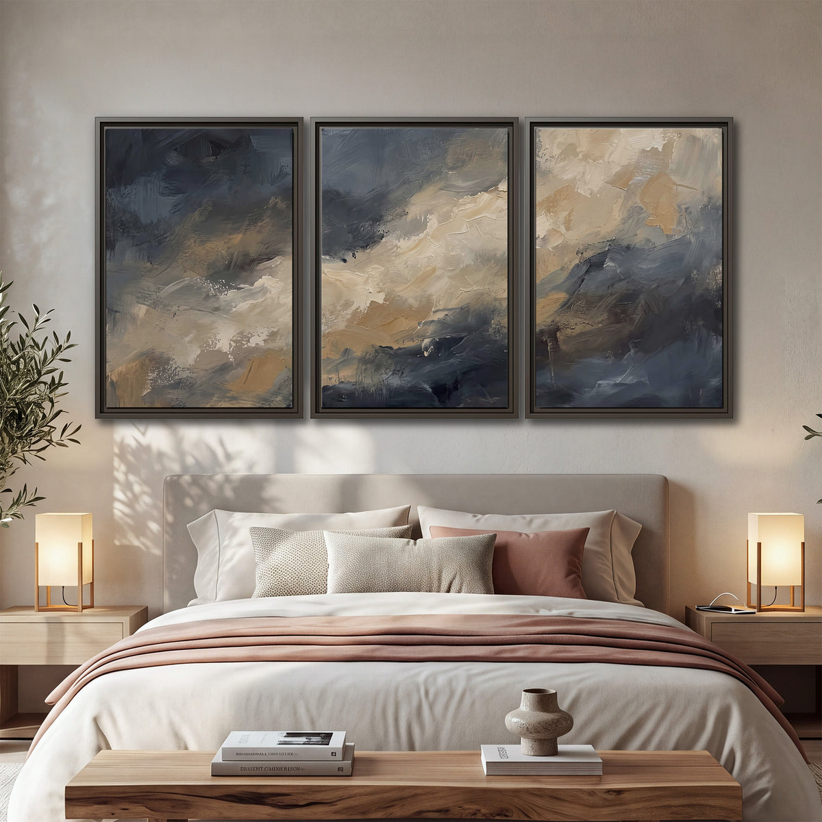 Sweeping charcoal and cream painted clouds with warm gold tones 3 piece framed canvas wall art displayed in a bedroom
